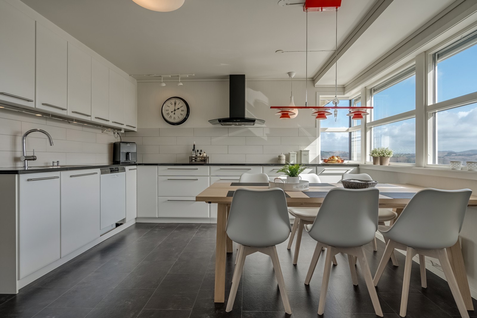 Skyvedør fra stua og inn til kjøkken med flott innredning fra Kvikk fra 2011, granitt benkeplate, fliser over hele benkeplata, skap på motsatt vegg med en granitt benkeplate. God spiseplass med flott utsikt på fjorden samt inn til egen terrasse. Galleribilde