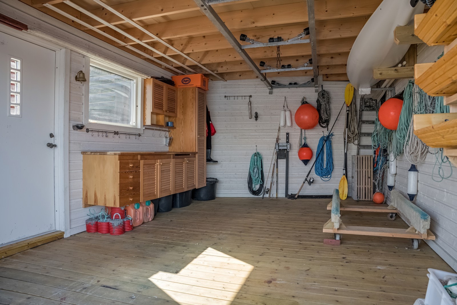 Underetasjen har panel på veggene, tregulv i flukt med brygga på utsiden. Foran naustet er det en liten trebrygge. Galleribilde