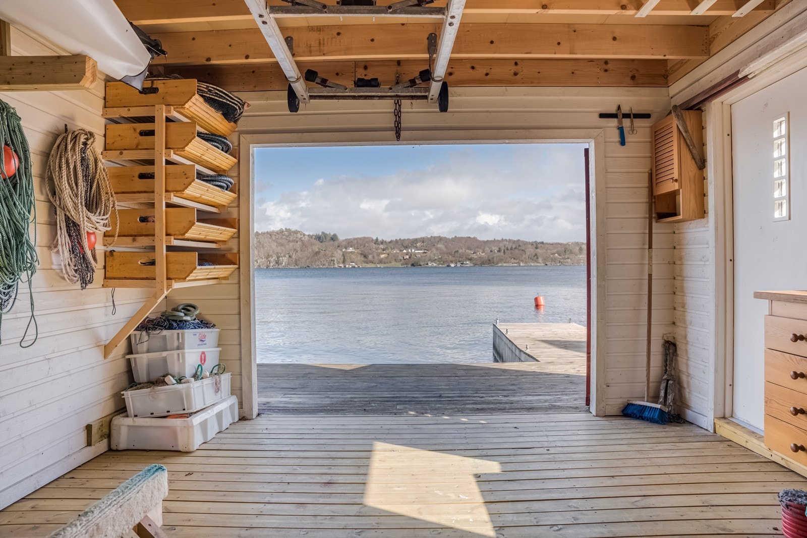 Underetasjen har panel på veggene, tregulv i flukt med brygga på utsiden. Sidedørsinngangen er laget etter avtale med forrige eier, men må påregnes å fjernes/tilpasses den dagen naboen vil bygge naust på sin tomt. Foran naustet er det en liten trebrygge. Galleribilde