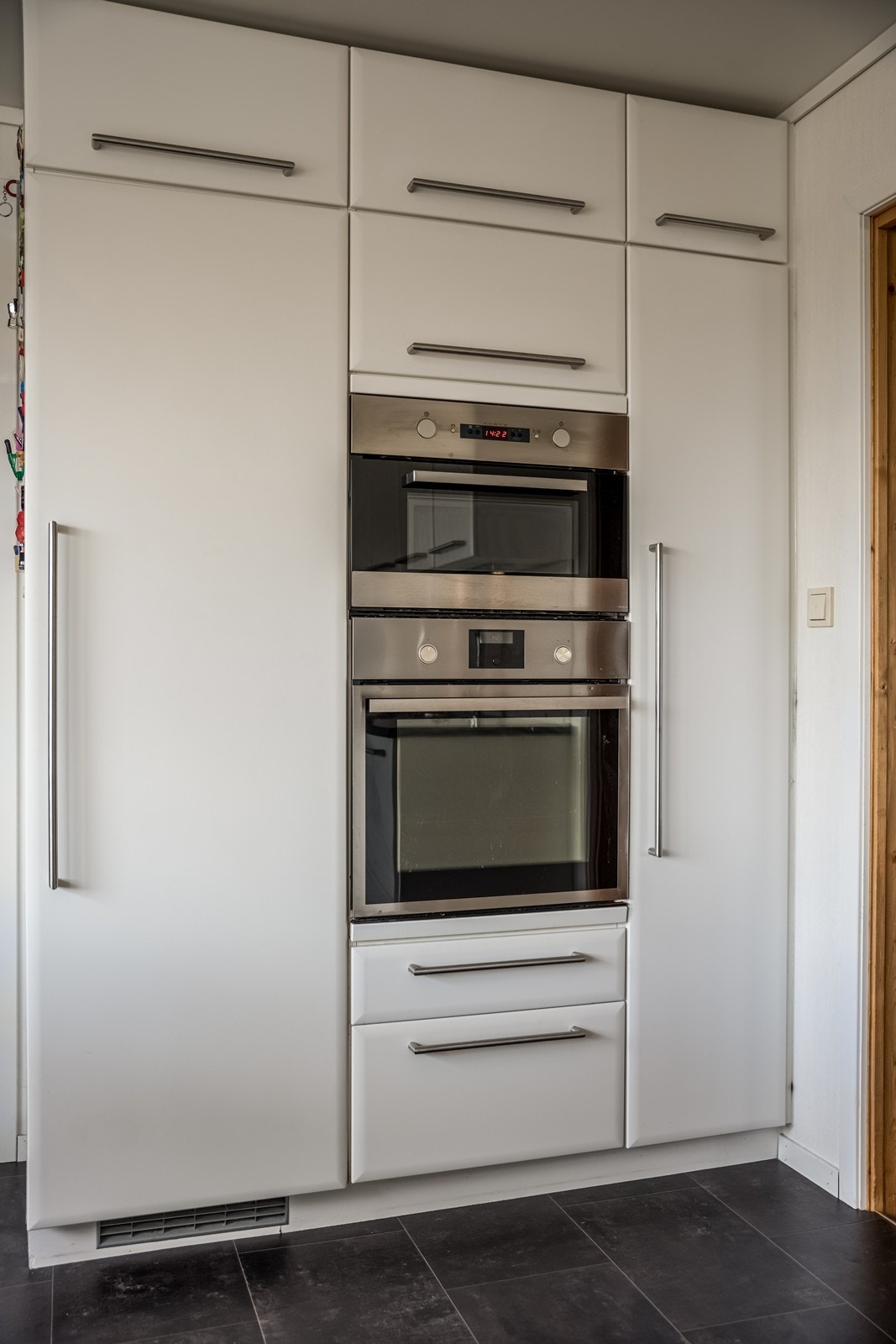 Flott innredning fra Kvikk fra 2011. Skap på motsatt vegg med en granitt benkeplate med trippel underskap og stekeovnseksjon med int. micro, int. kjøleskap, int. stekeovn, et høyt skap og 6 skuffer Galleribilde