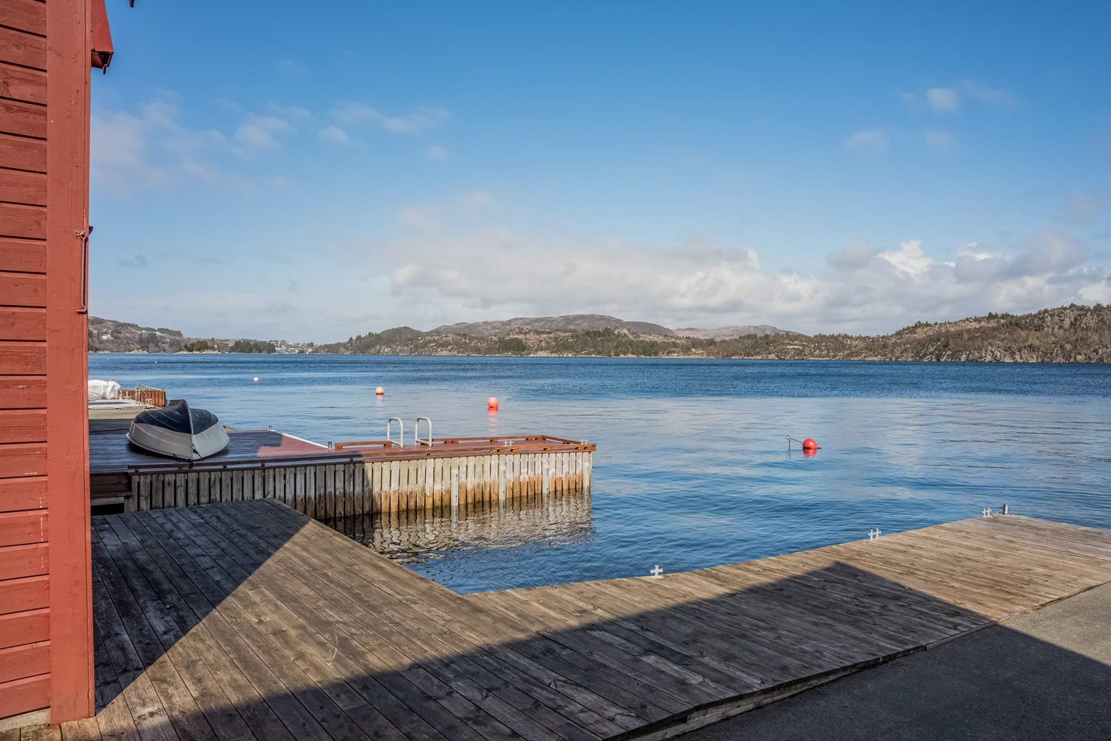 Foran naustet er det en liten trebrygge. Delvis felles trebrygge med naboen som strekker seg utover sjøen. Denne eiendommen har siden mot nord, mens eier av Pedersbakken 15 har fronten og siden mot sør. Galleribilde