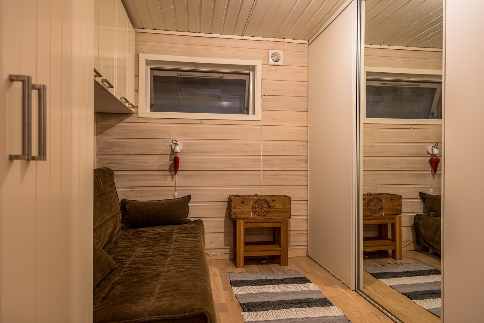 Bod/hobbyrom med sovesofa, skyvedørsgarderobe, dobbelt garderobeskap og fem enkle skap. Eikeparkett på gulv og hvitbeiset panel på vegger. Galleribilde