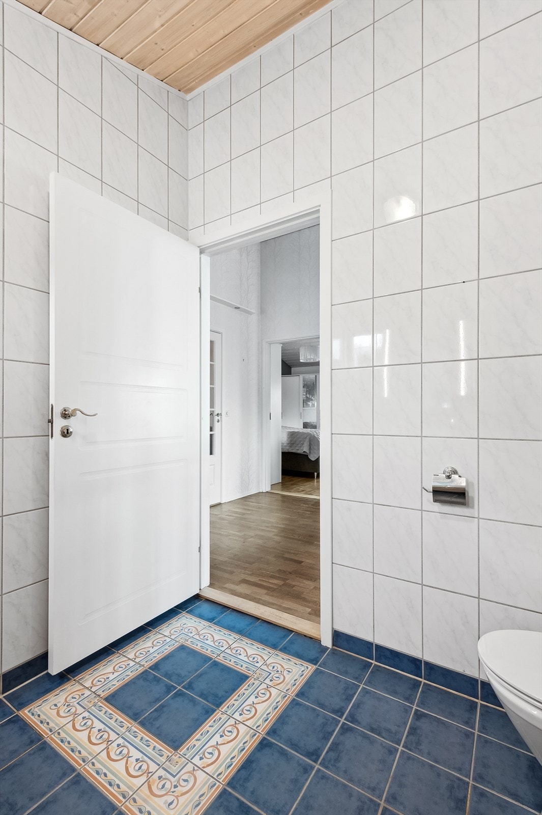 Mønstrete flislegging rett innenfor døren til badet. Galleribilde