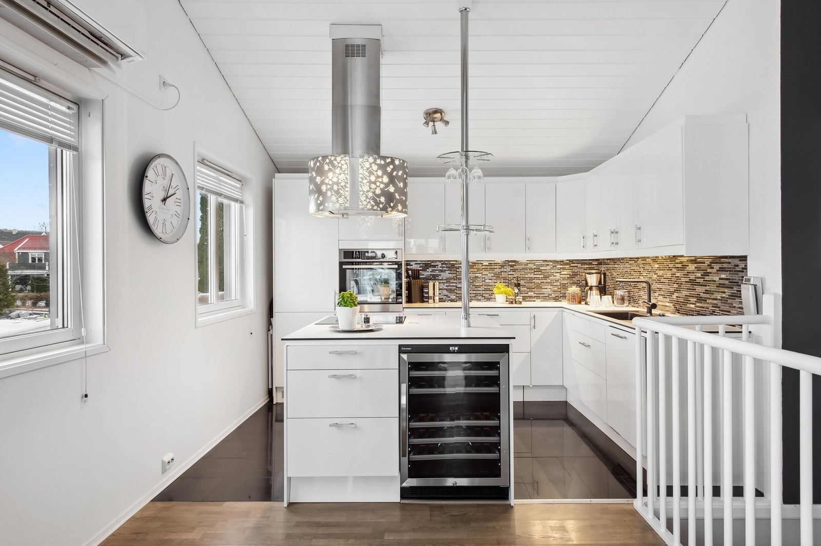 Kjøkken i hovedetasjen med mørke fliser på gulvet og lysmalte vegger. Galleribilde