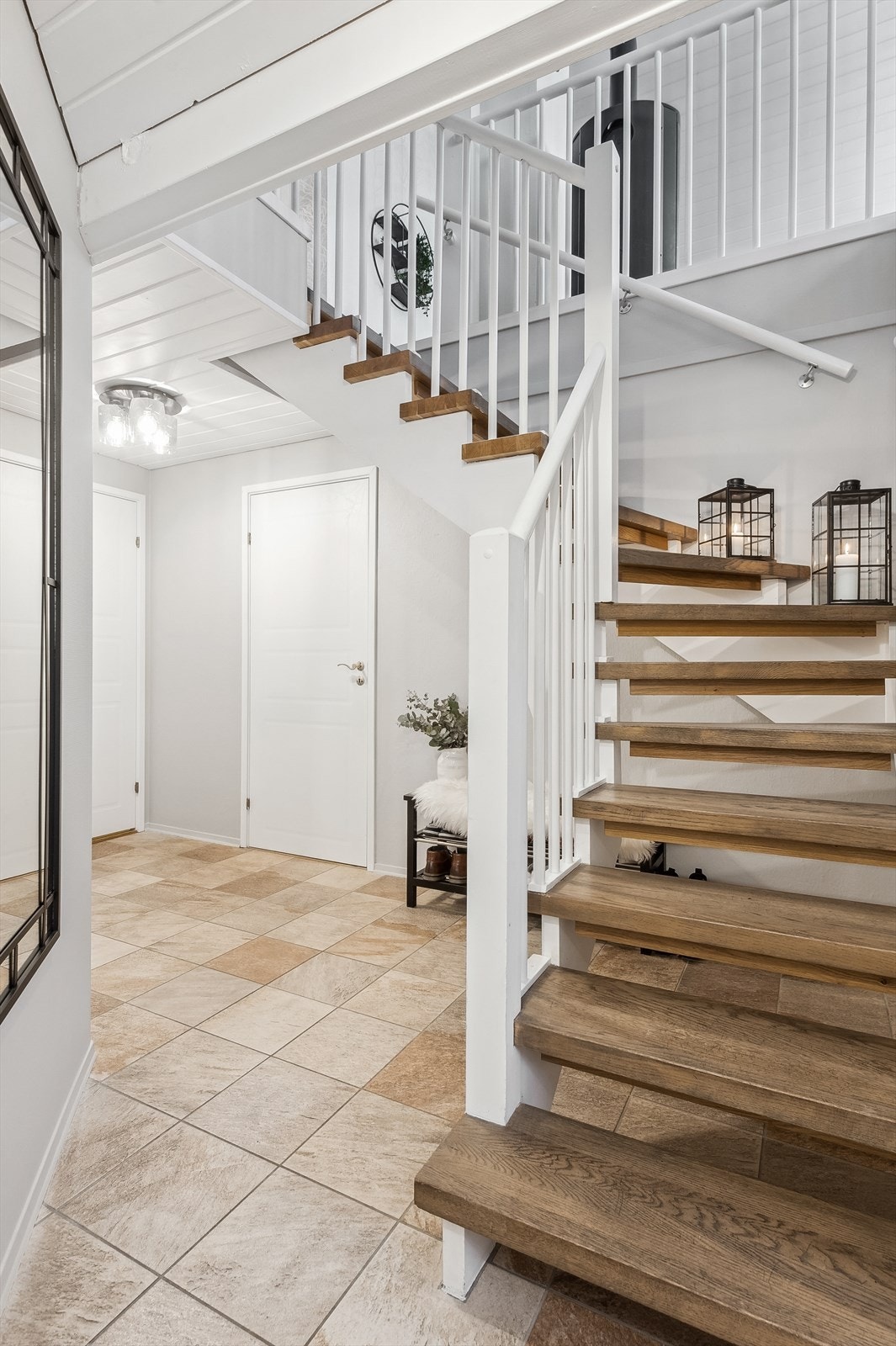 Gang i underetasjen med fliser på gulvet og lysmalte vegger. Galleribilde