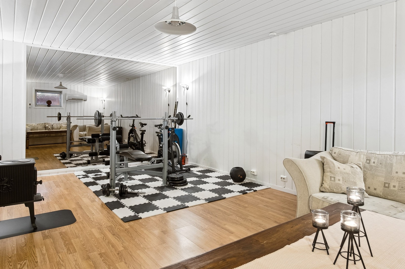 En vegg i stuen har speil på hele veggflaten. Stuen er romslig med god plass til det stuemøblementet man ønsker. Galleribilde