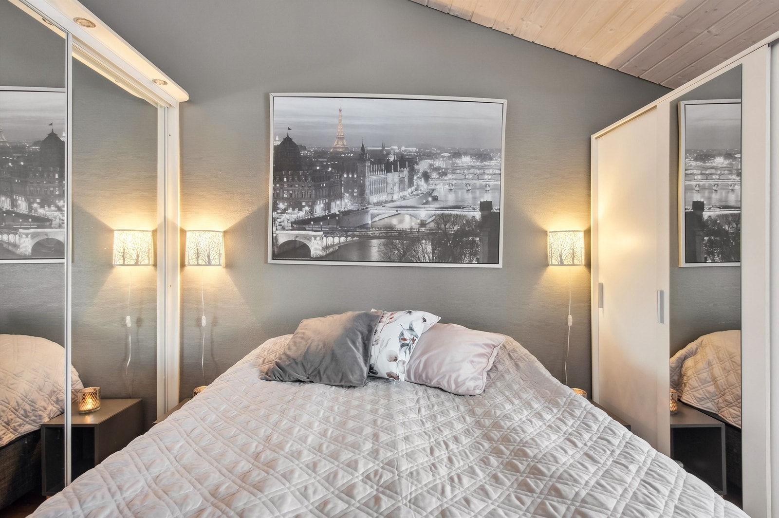 Rommet har etablert en skyvedørsgarderobe med speildører og garderobeskap med speil og tette dører. Galleribilde