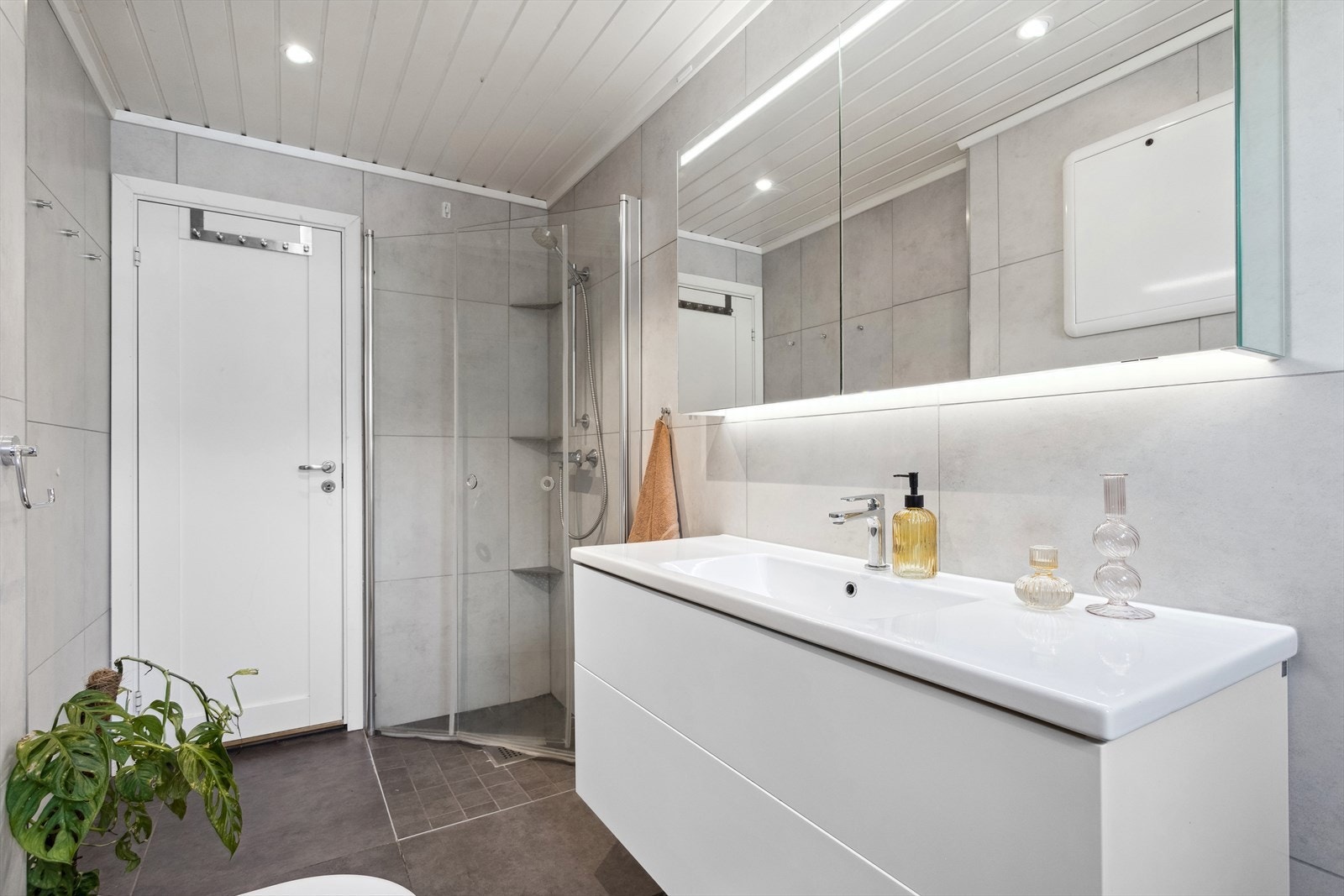 Baderommet er ca 5,9 m² og har flis på gulv og vegg, malt panel i himling. Galleribilde