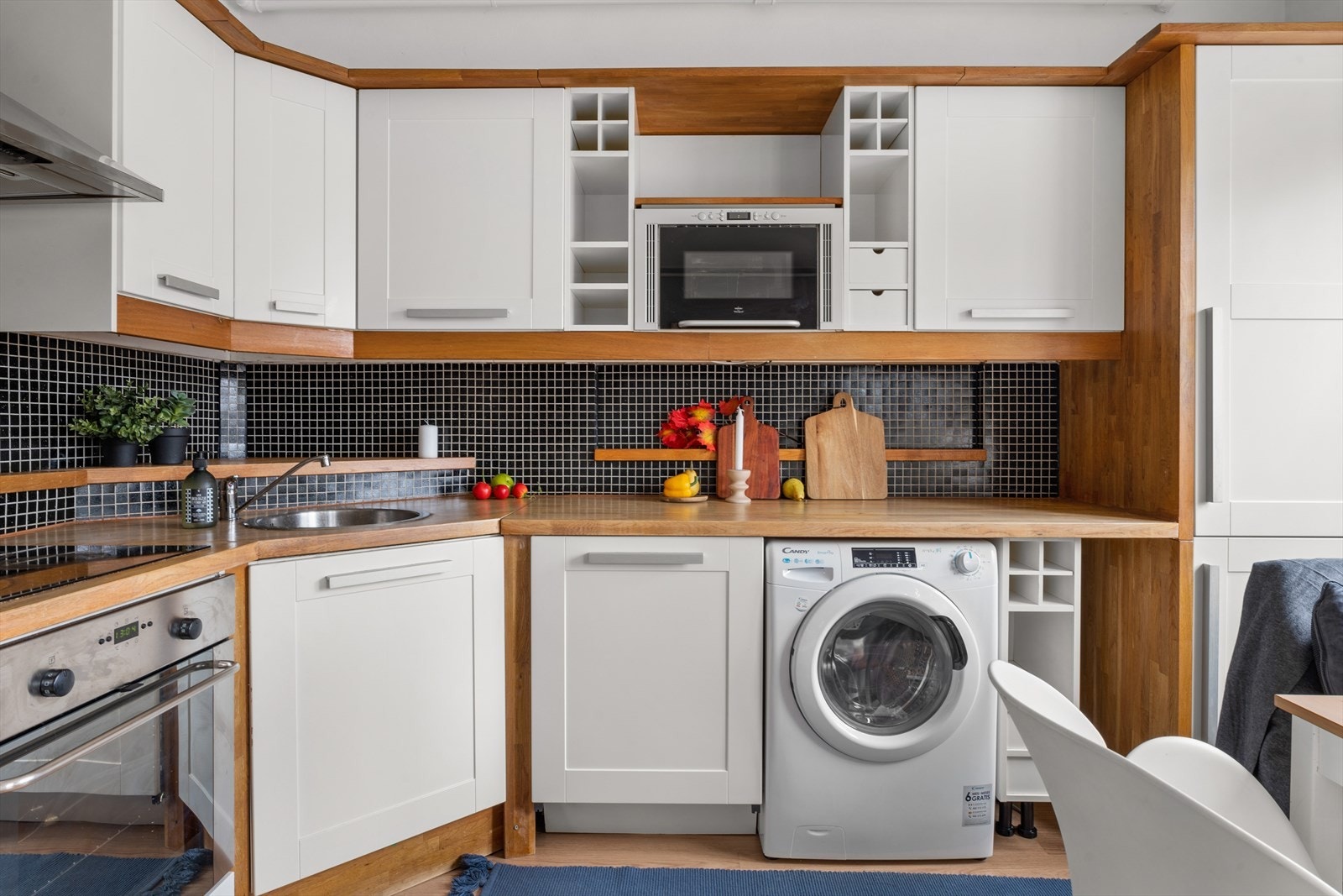 Kjøkkeninnredning med profilerte fronter. Heltre benkeplate med nedfelt kum i rustfritt stål. Mosaikkfliser på vegg over benkeskap. Galleribilde