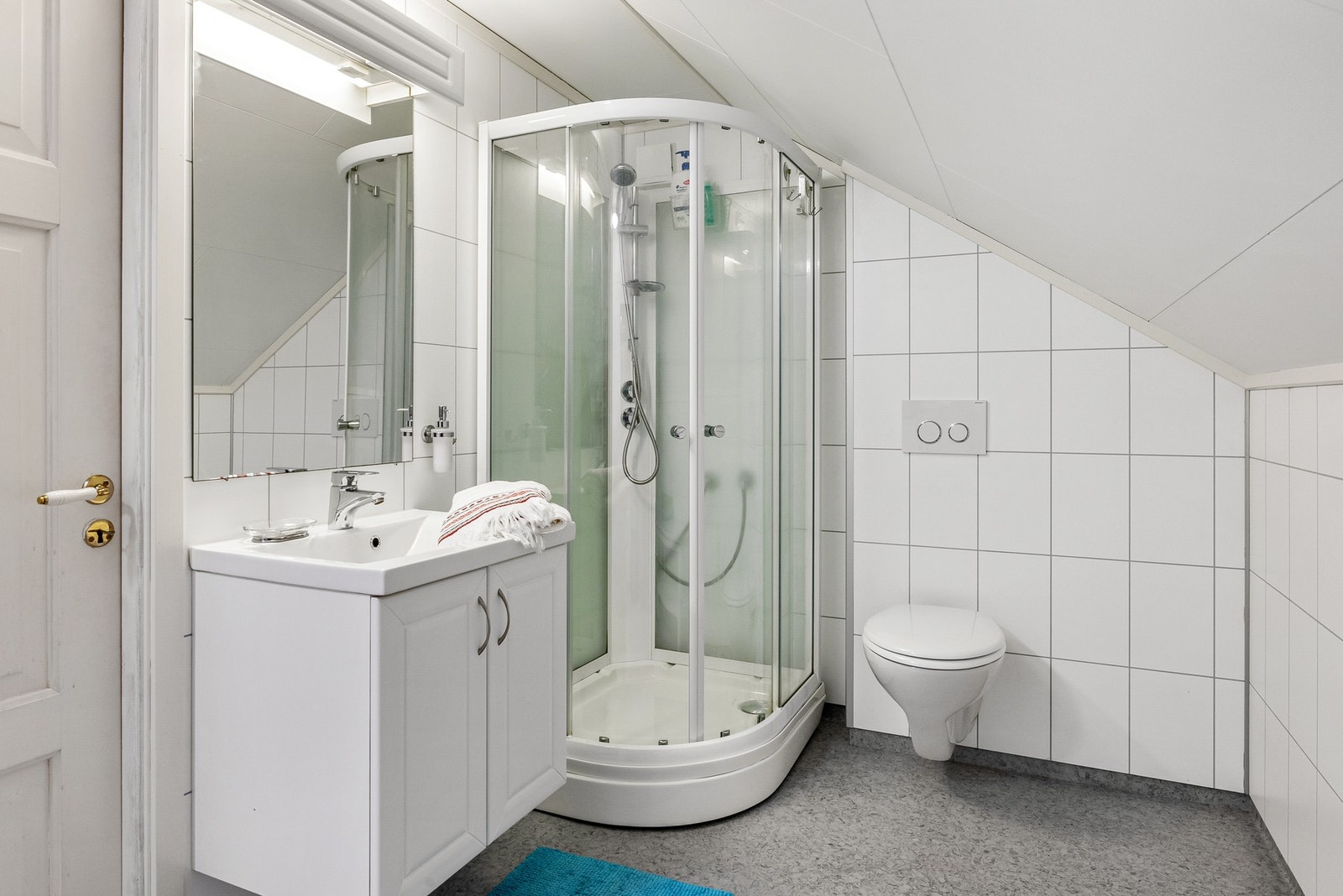 Bad med innredning, veggmontert toalett og dusjkabinett Galleribilde