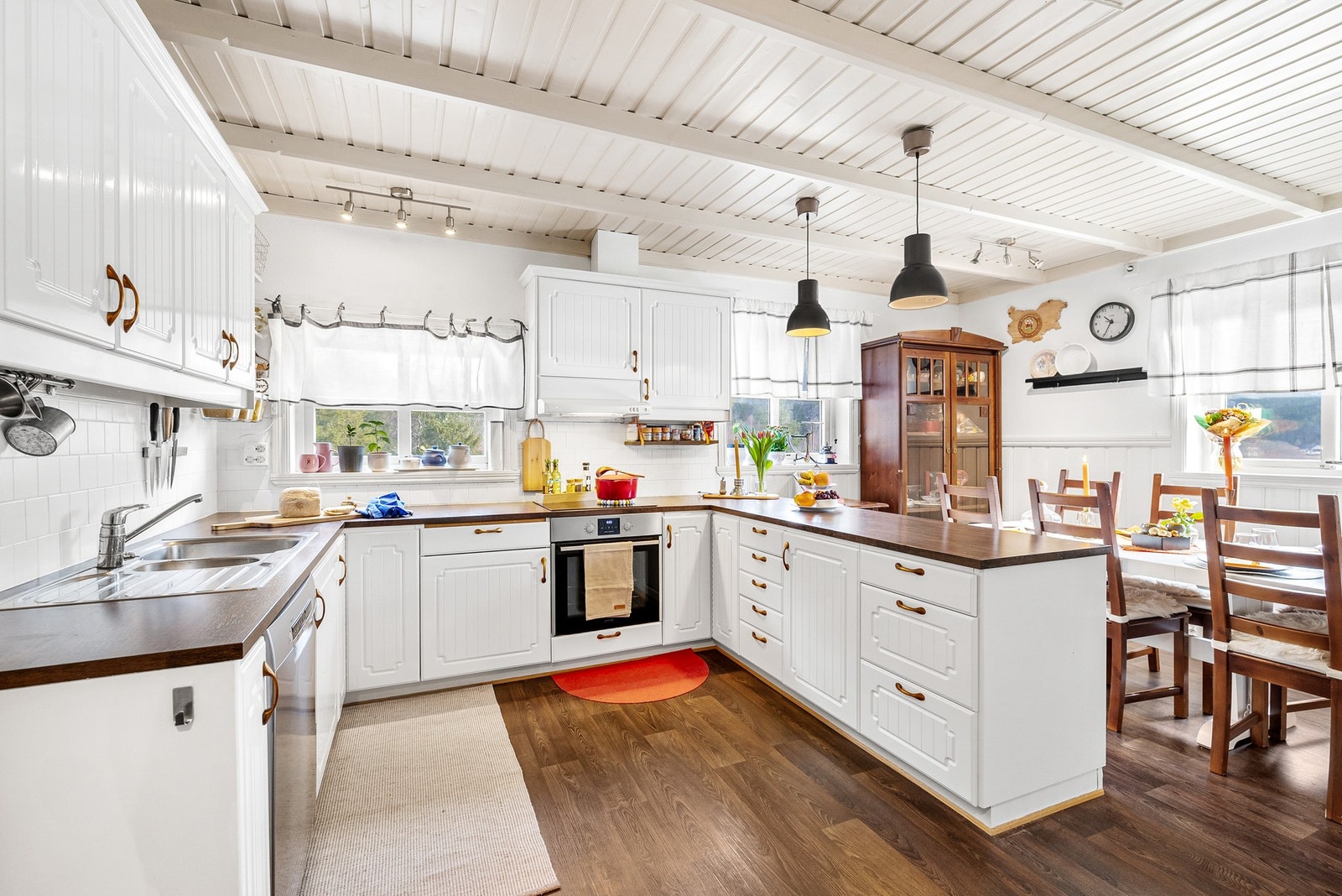 Kjøkkenet har innredning med profilerte fronter og benkeplate av laminat Galleribilde