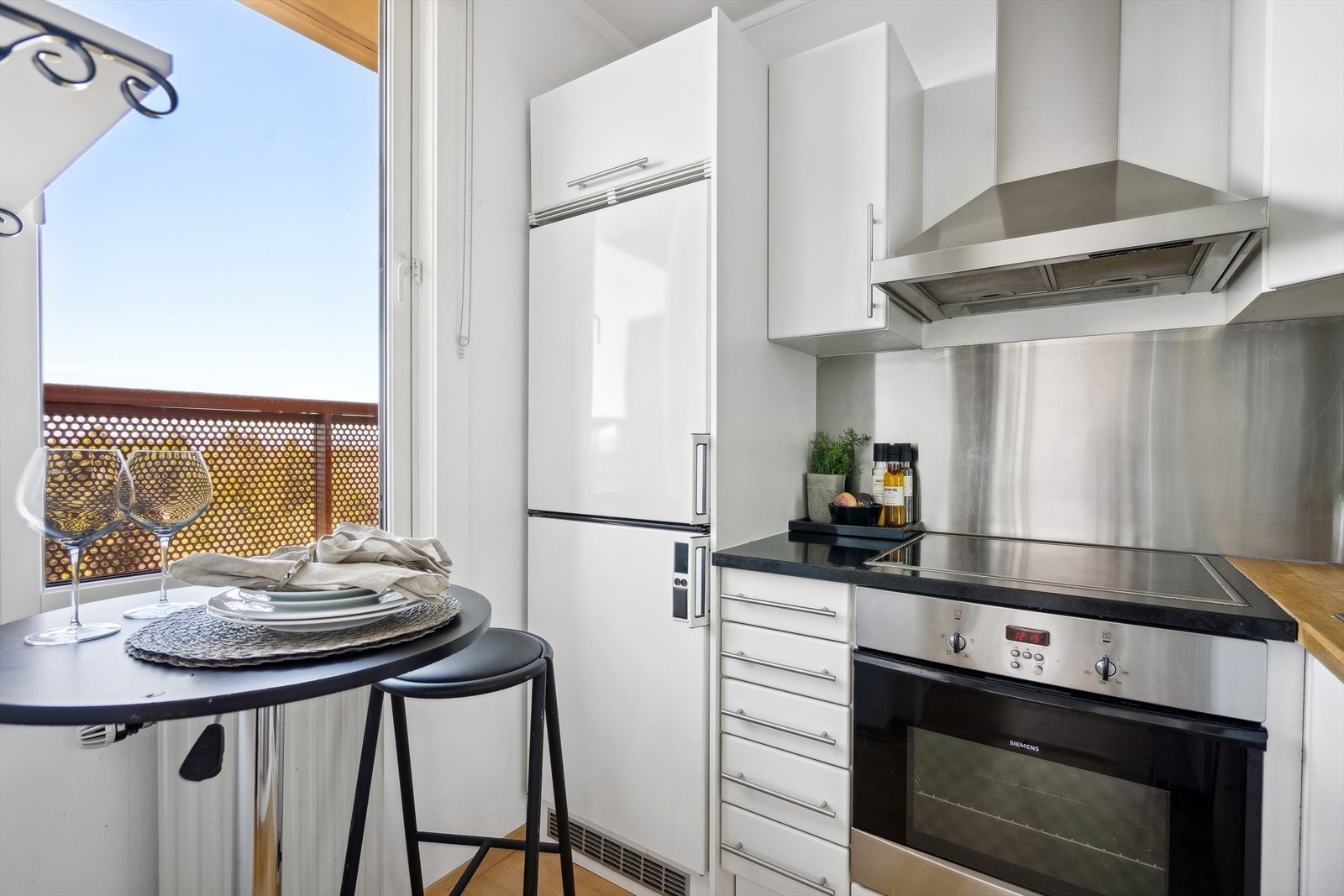 Kjøkkenninnredning fra Ikea med glatte, folierte fronter og heltre benkeplate med nedfelt platetopp. Galleribilde