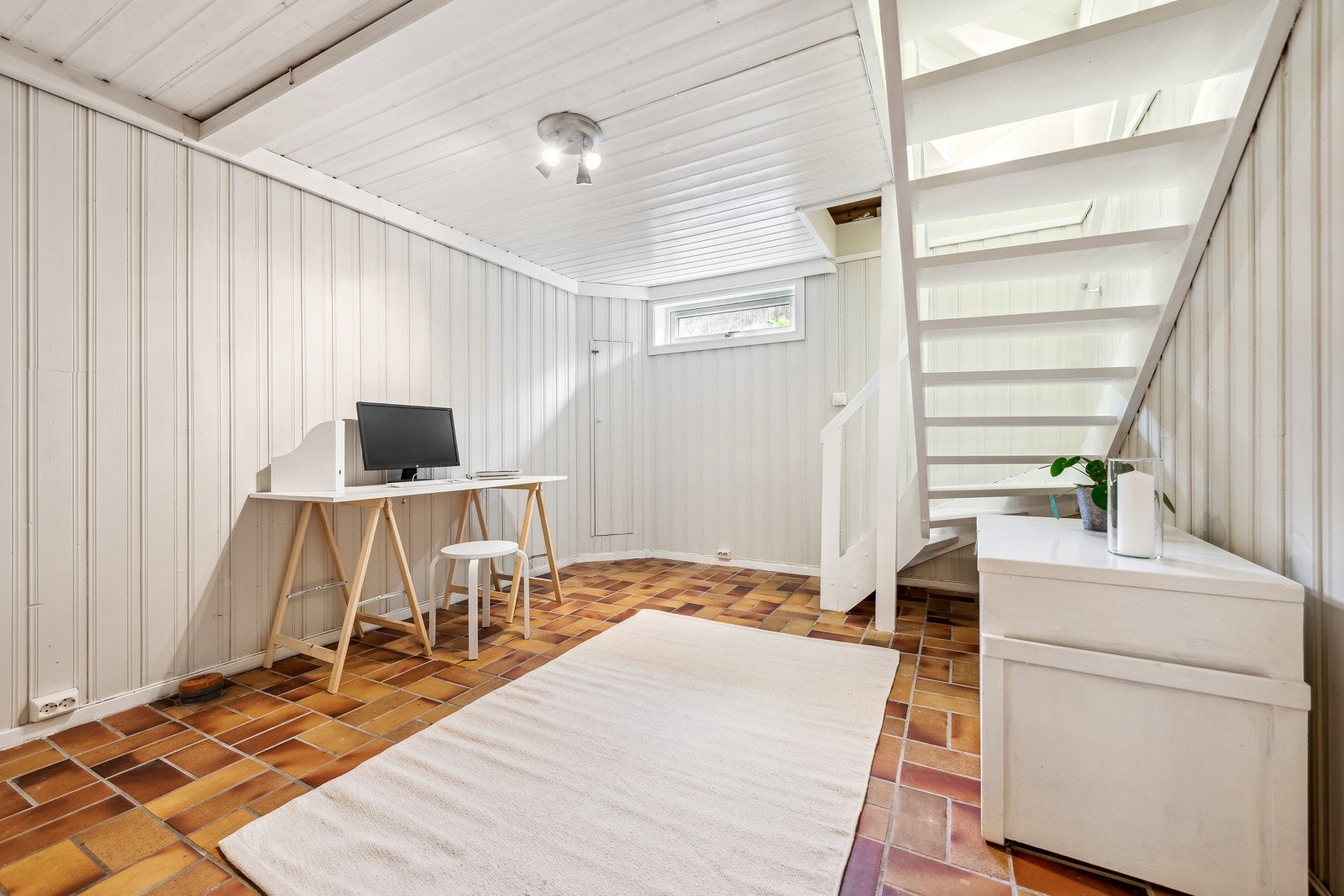 Trapperom fra hovedetasje til underetasje. Et lyst rom som kan nyttes som forstue eller som i dag, et kontor. Galleribilde