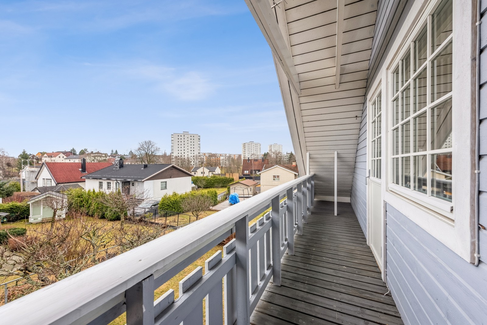 Utgang fra soverom til 5 kvm overbygget terrasse med utsikt til hage og bebyggelse. Galleribilde