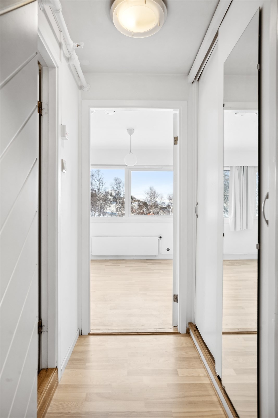 Inngang med bad til venstre og en liten garderobe tll høyre før du kommer inn i stuen og kjøkkenet Galleribilde