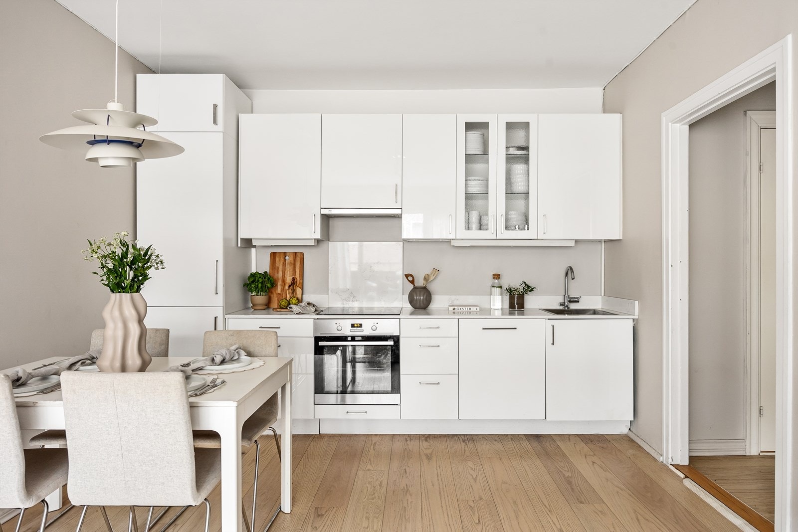 Lys innredning med glatte fronter og benkeplate med backsplash Galleribilde