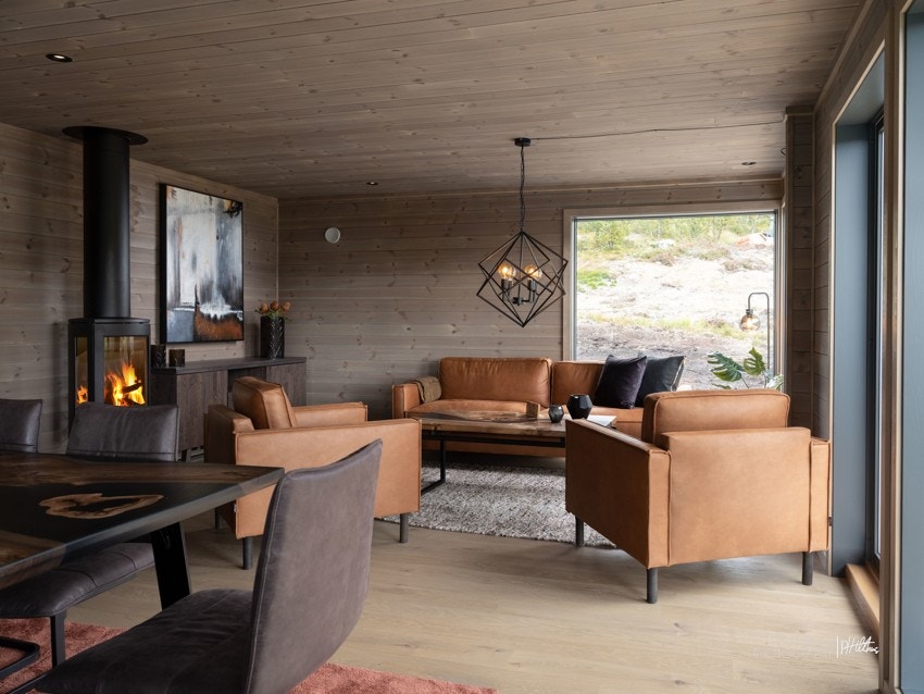 Romslig stue med lekre overflater, vedovn og naturlige møbelsoner. Galleribilde