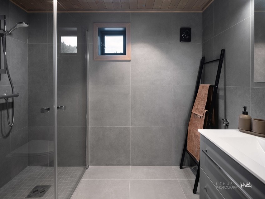 Helfliset bad med tidsriktige fliser på gulv og vegger. Varmekabler i gulv. Galleribilde