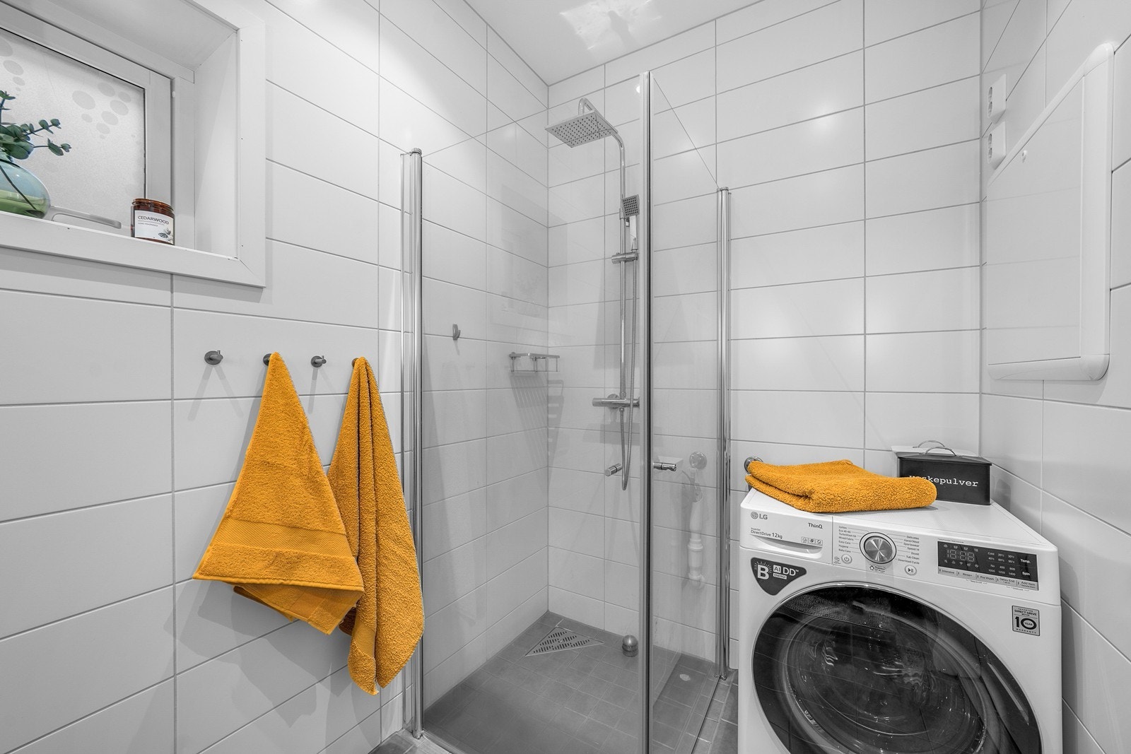 Nedsenket dusjhjørne med mindre fliser på gulv, regnfallsdusj, designsluk og innfellbare glassdører. Rommet har opplegg og plass for både vaskemaskin og tørketrommel. Vaskemaskin i rommet ved visning kan medfølge etter avtale med eier! Galleribilde