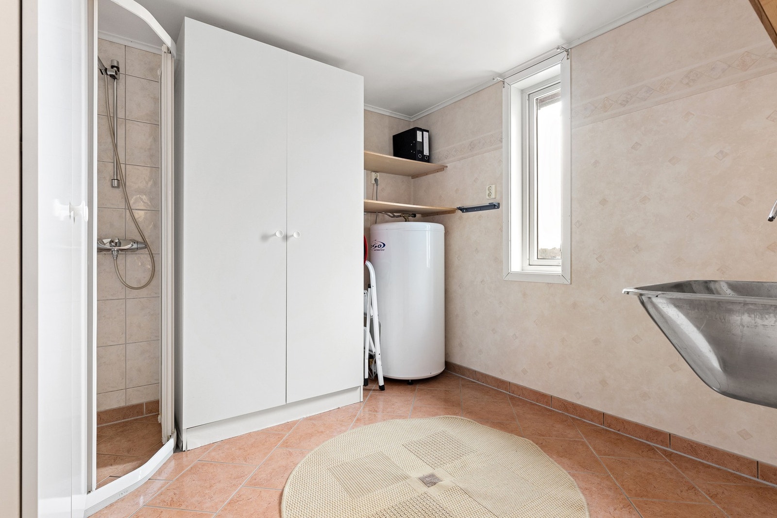 Tilliggende badet finnes et praktisk vaskerom med opplegg for vaskemaskin, VVB, utslagsvask, oppbevaringsskap og dusjnisje. Galleribilde