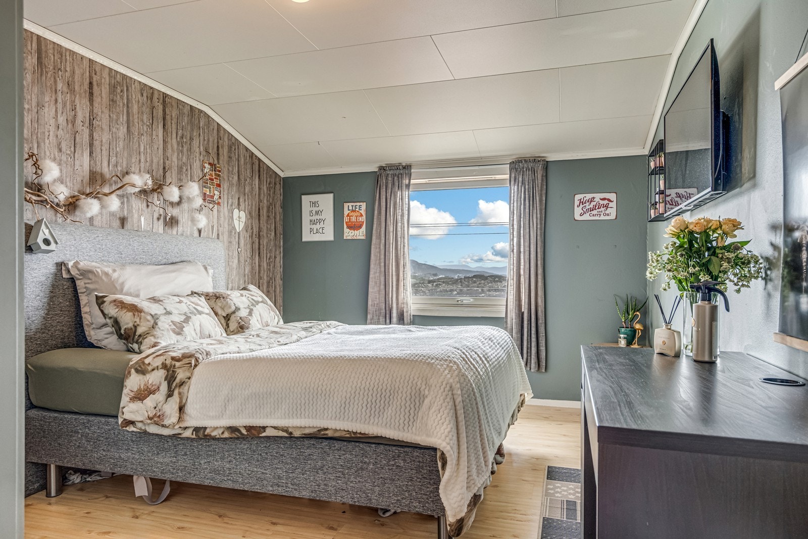 Dobbelt soverom med laminatgulv, tapetserte vegger, dobbelt garderobeskap og veggmontert TV (festet vil stå igjen). Galleribilde