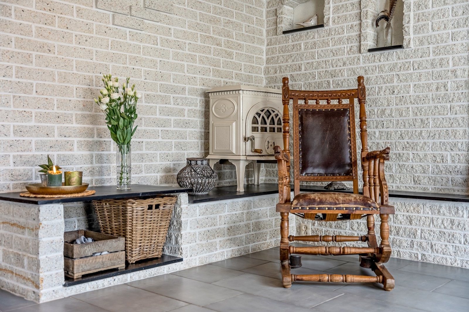 Inngang til en svært romslig hall med fliser og varmekabler på gulv, trapp opp til loftsetasjen, fint integrert speil i murvegg, vedovn, spotter i tak, vinduer nesten fra gulv til tak og skråvindu mot inngangspartiet. Galleribilde