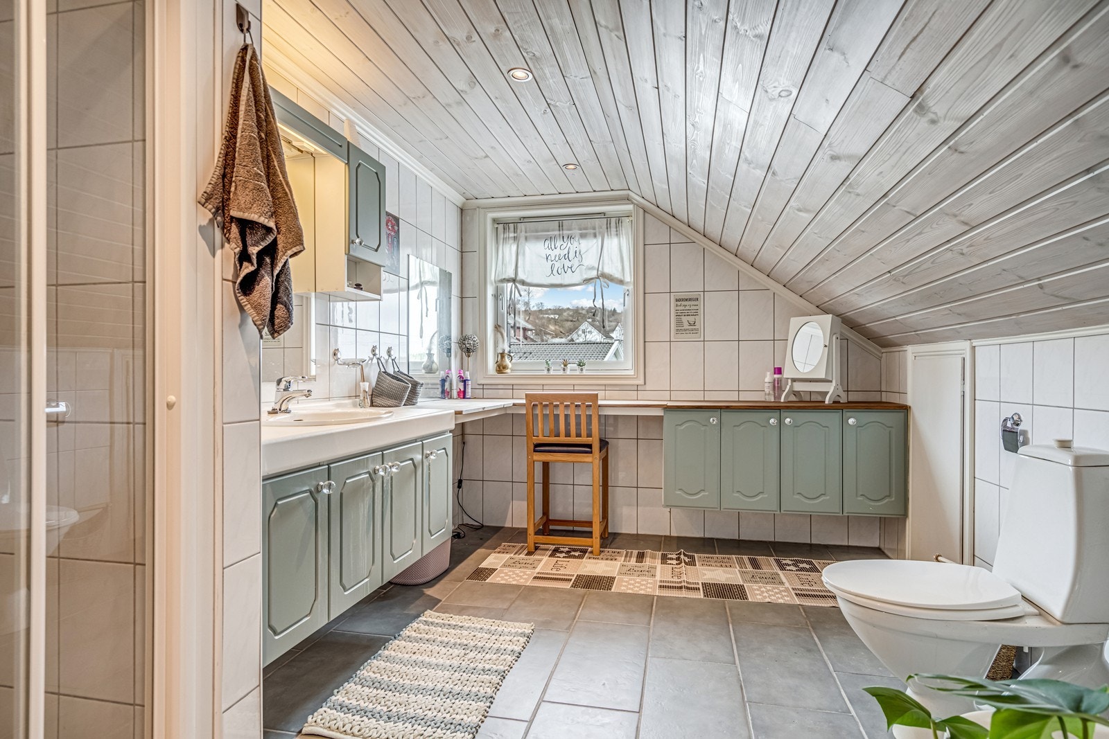 Flislagt bad med badekar, bidê, wc, dusjnisje som ikke er i bruk, baderomsinnredning med fire undeskap, to speilskap, benkeplate, lang ekstra benkeplate i hjørne med fire underskap i enden. Spotter i tak. Luke til kott. Galleribilde