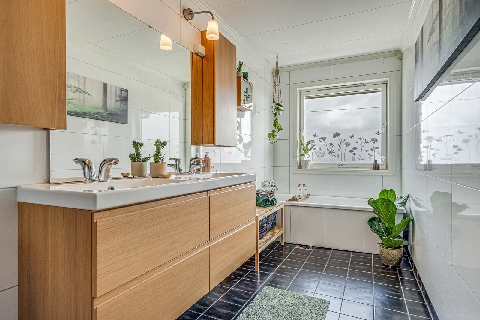 Bad 1. etg. med fliser og varmekabler på gulv, baderomsplater på vegger, dusjkabinett med regnvannsdusj, wc, baderomsinnredning med dobbel servant, fire underskuffer, dobbelt speilskap, stort fastmontert speil, badekar og nydelig fjordutsikt. Galleribilde