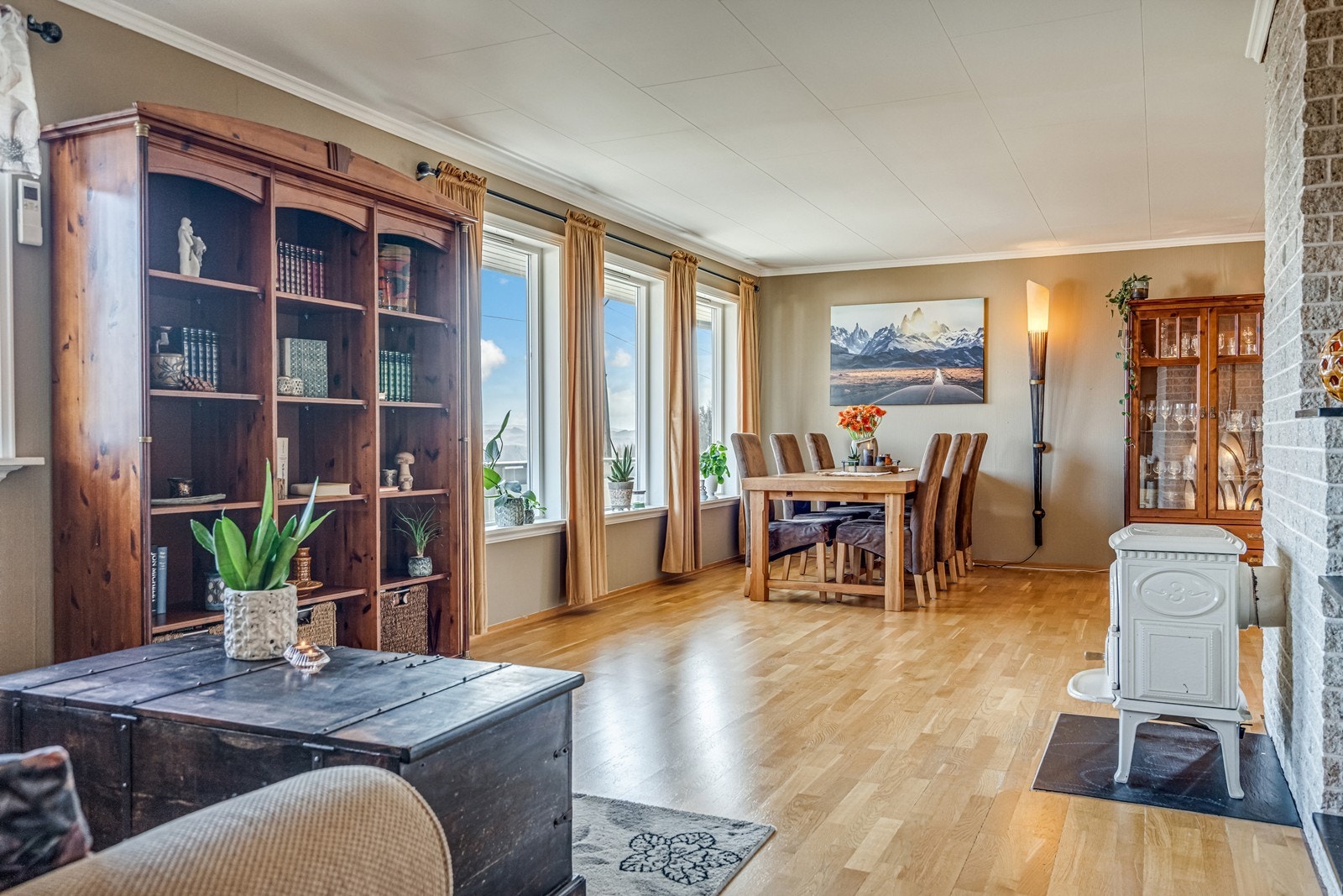 Vinkelstue med både varmepumpe og vedovn, eikeparkett på gulv, flott fjordutsikt og utgang til terrasse med tett tak over. Galleribilde