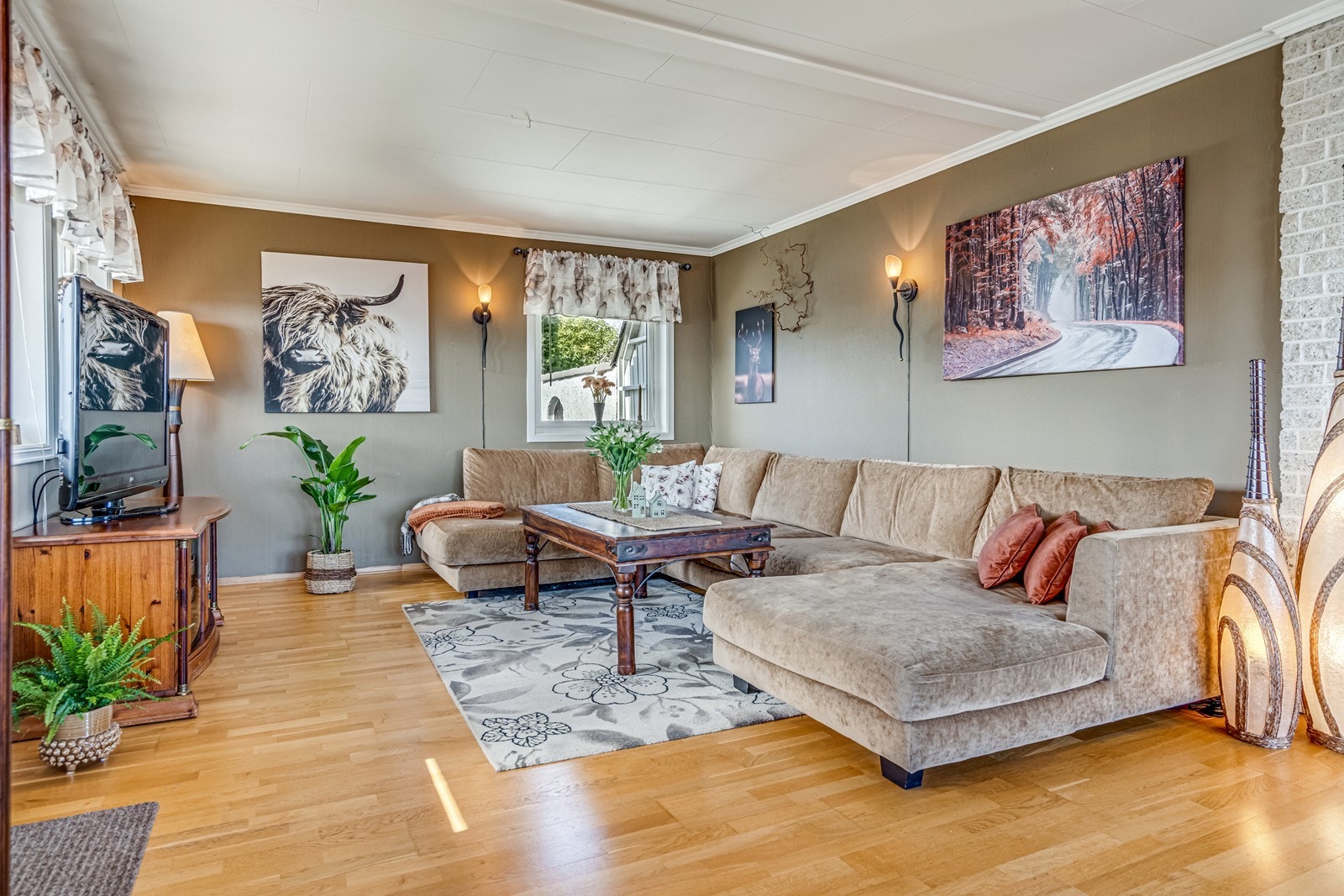 Vinkelstue med både varmepumpe og vedovn, eikeparkett på gulv, flott fjordutsikt og utgang til terrasse med tett tak over. Galleribilde