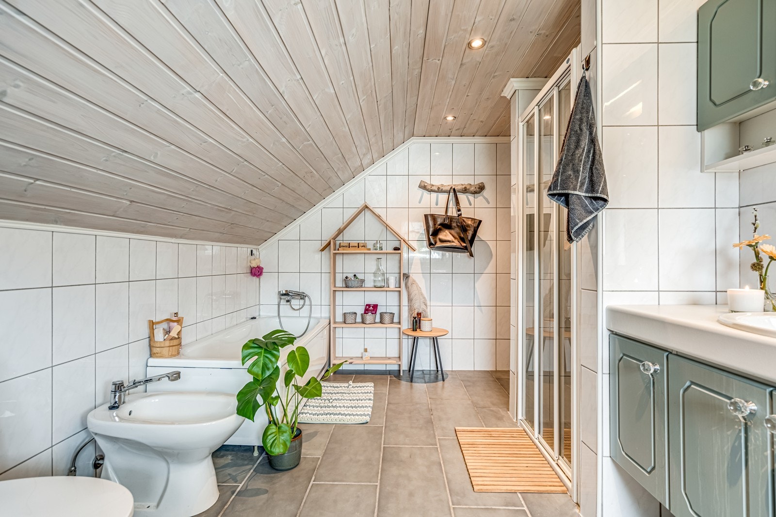 Flislagt bad med badekar, bidê, wc, dusjnisje som ikke er i bruk, baderomsinnredning med fire undeskap, to speilskap, benkeplate, lang ekstra benkeplate i hjørne med fire underskap i enden. Spotter i tak. Luke til kott. Galleribilde