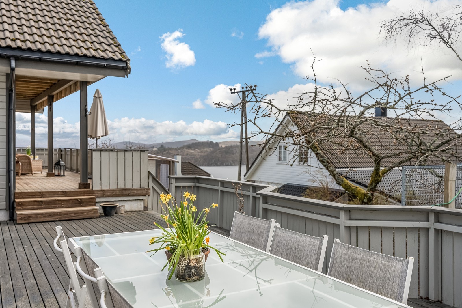 Fra terrassen er det også 2 trappetrinn ned til stor terrasse på bakkevinå mot sør med flott utepeis og skillevegg med dør til parkeringsområdet. Galleribilde