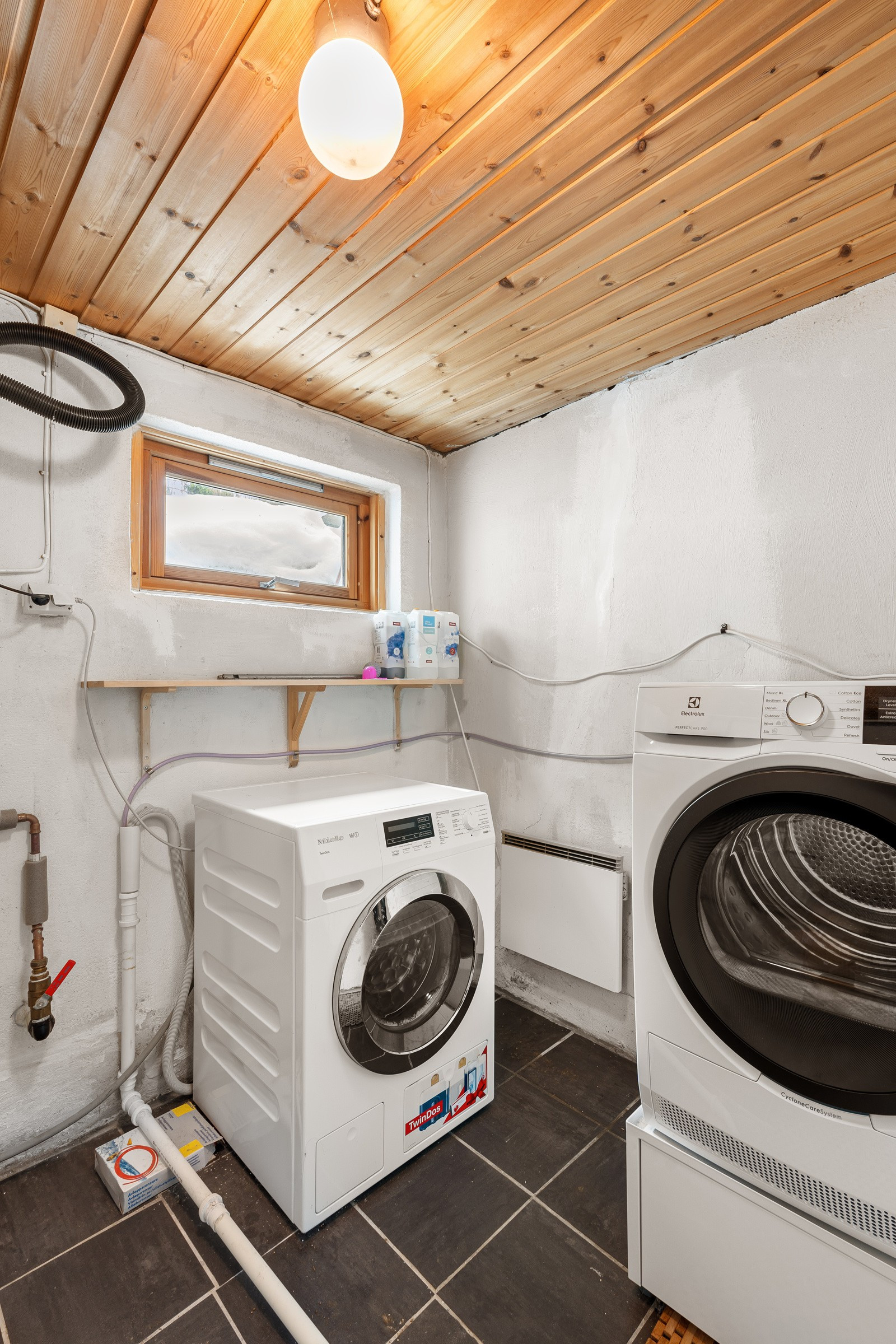 Vaskerom nede i underetasjen med opplegg til både vaskemaskin og tørketrommel.
