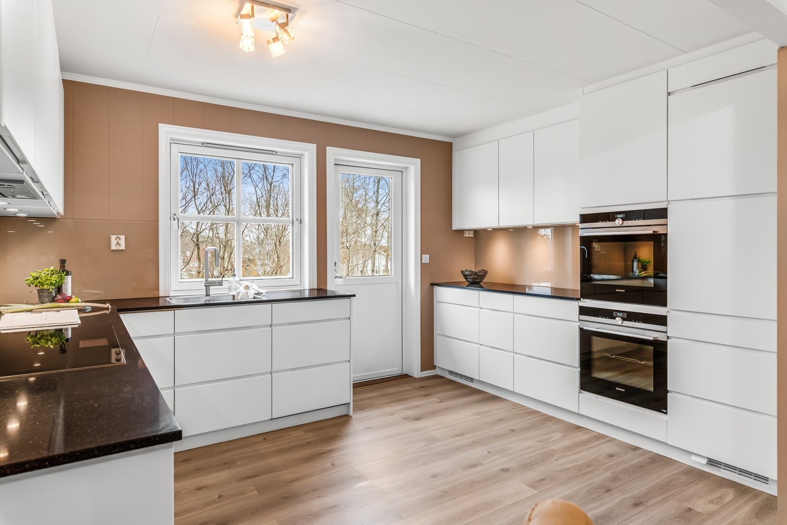 Hjertet i huset er et lekkert og moderne kjøkken fra 2017, med egen spiseplass, 1-stavs laminatgulv (Berry Alloc High-Tech Laminate) og vegger malt i en trendy jordnyanse. Galleribilde