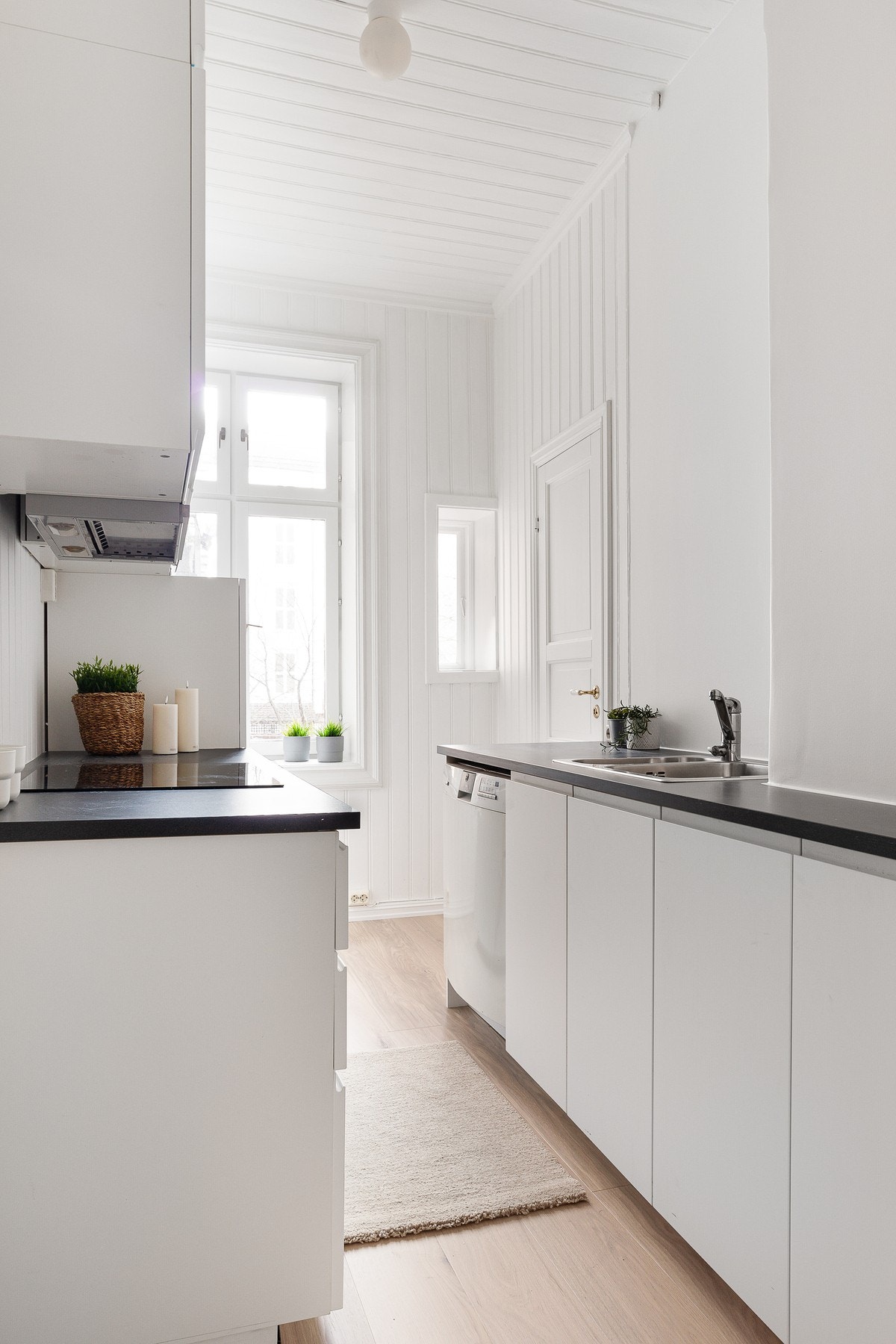 Det er innredning med folierte glatte fronter, benkeplate med nedfelt vaskekum og keramisk platetopp. Galleribilde