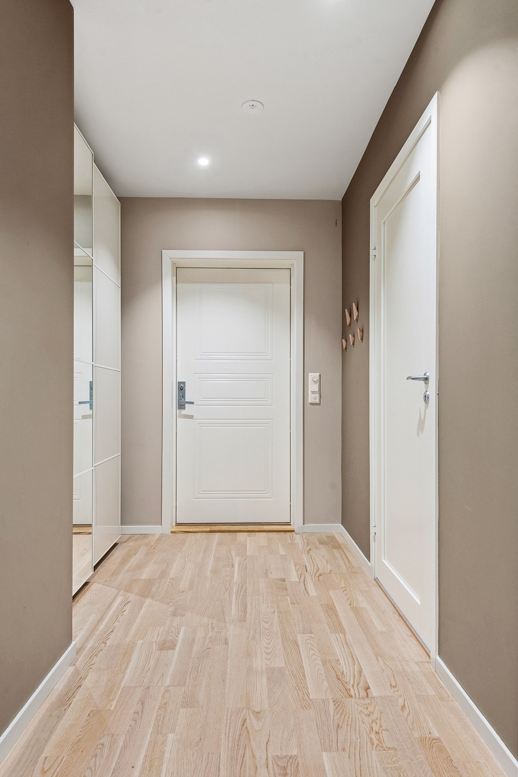 Romslig entré med praktisk skyvedørsgarderobe med speil. Galleribilde