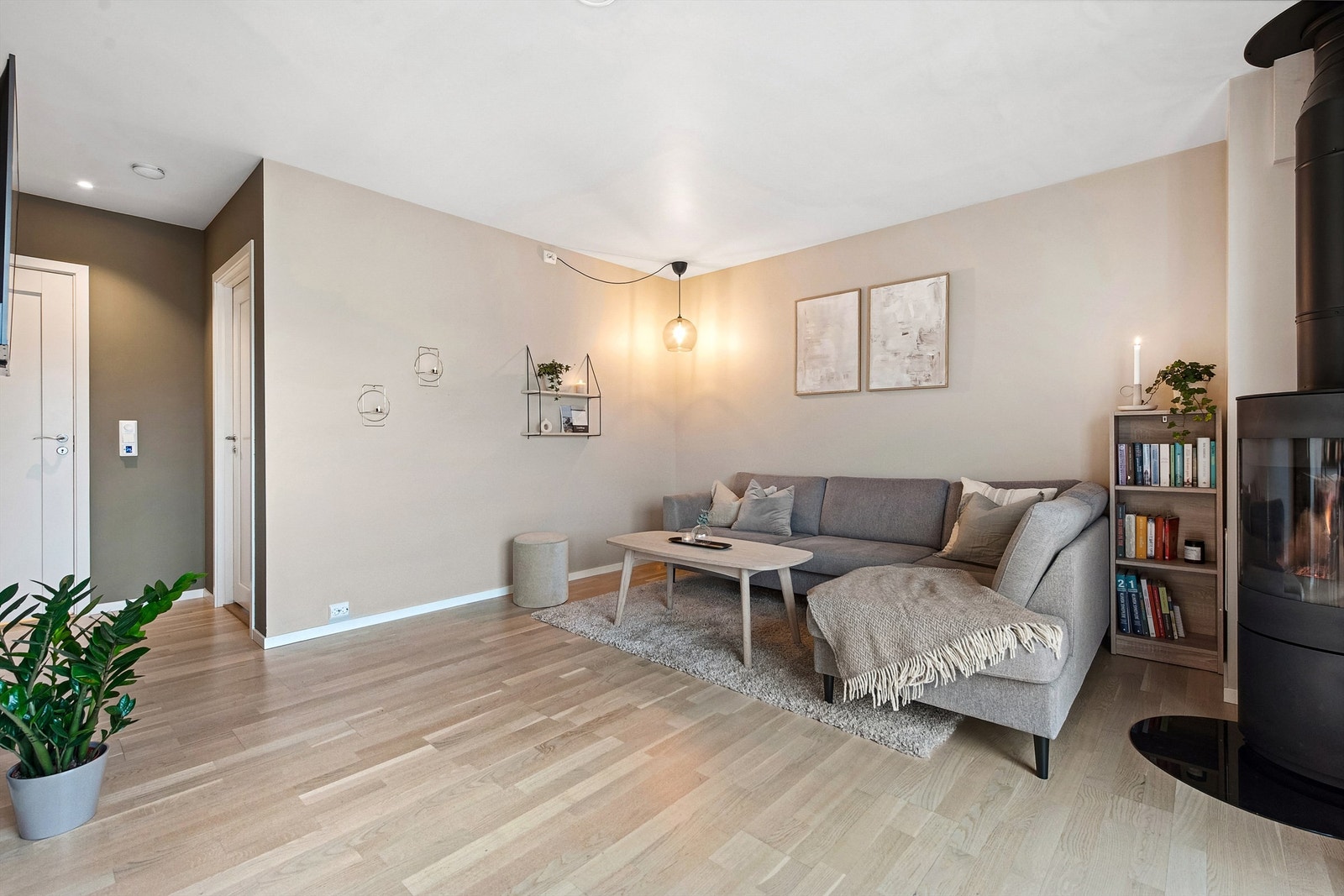 Lys og moderne stue med lys parkett, koselig peis og harmonisk fargepalett. Galleribilde