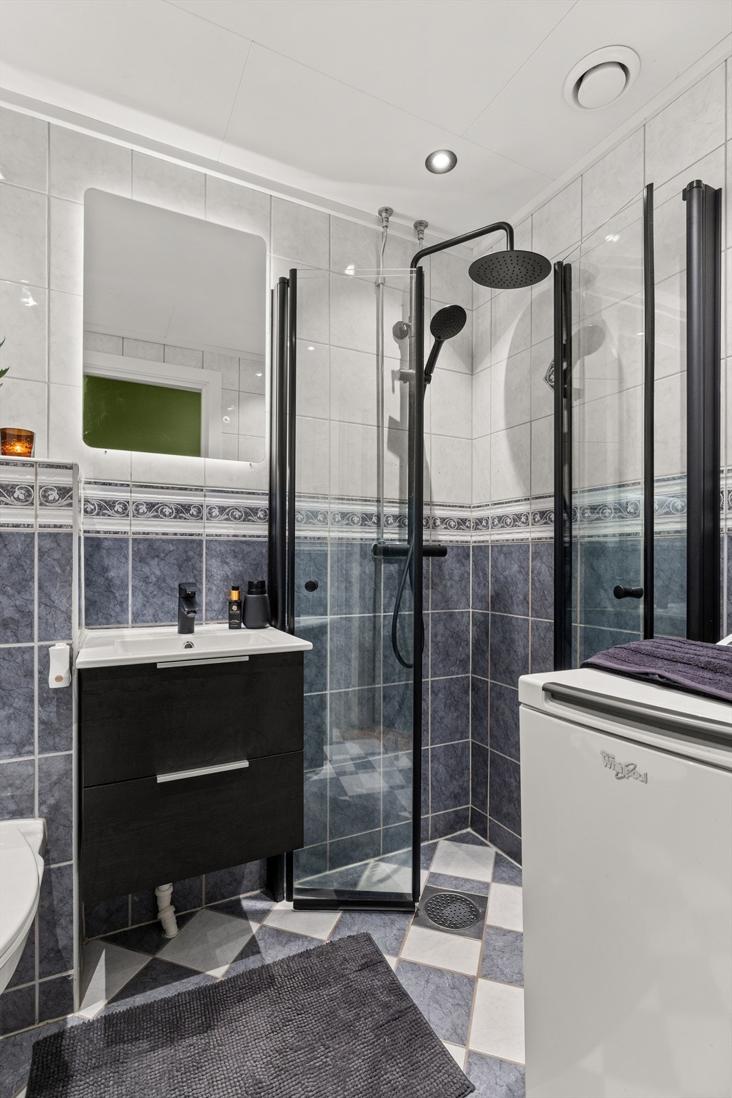 Badet har elektriske varmekabler på gulv, praktiske innfellbare dusjdører og opplegg for vaskasmaskin Galleribilde