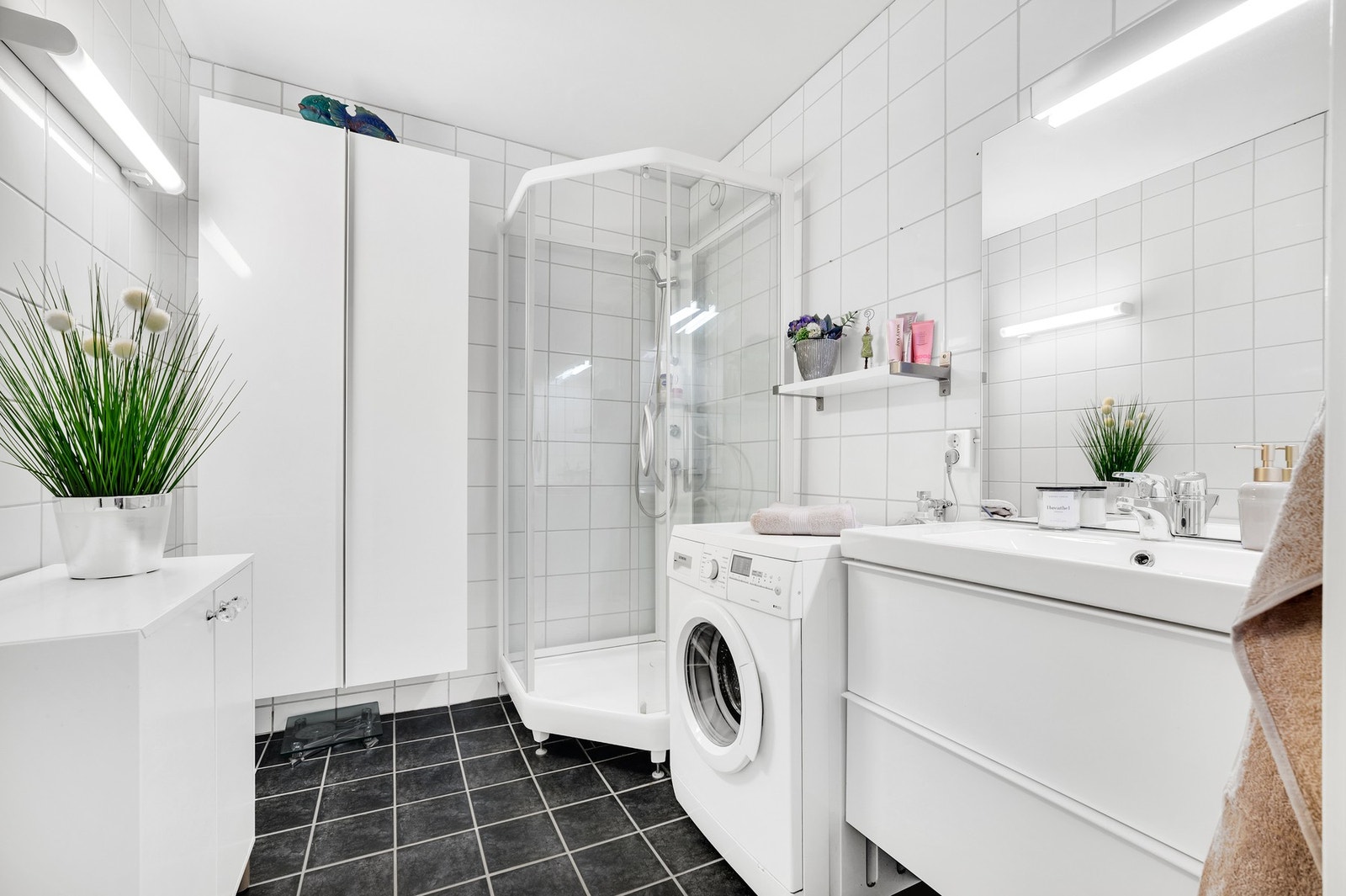 Pent flislagt bad med varmekabler i gulvet og opplegg for vaskemaskin. Galleribilde