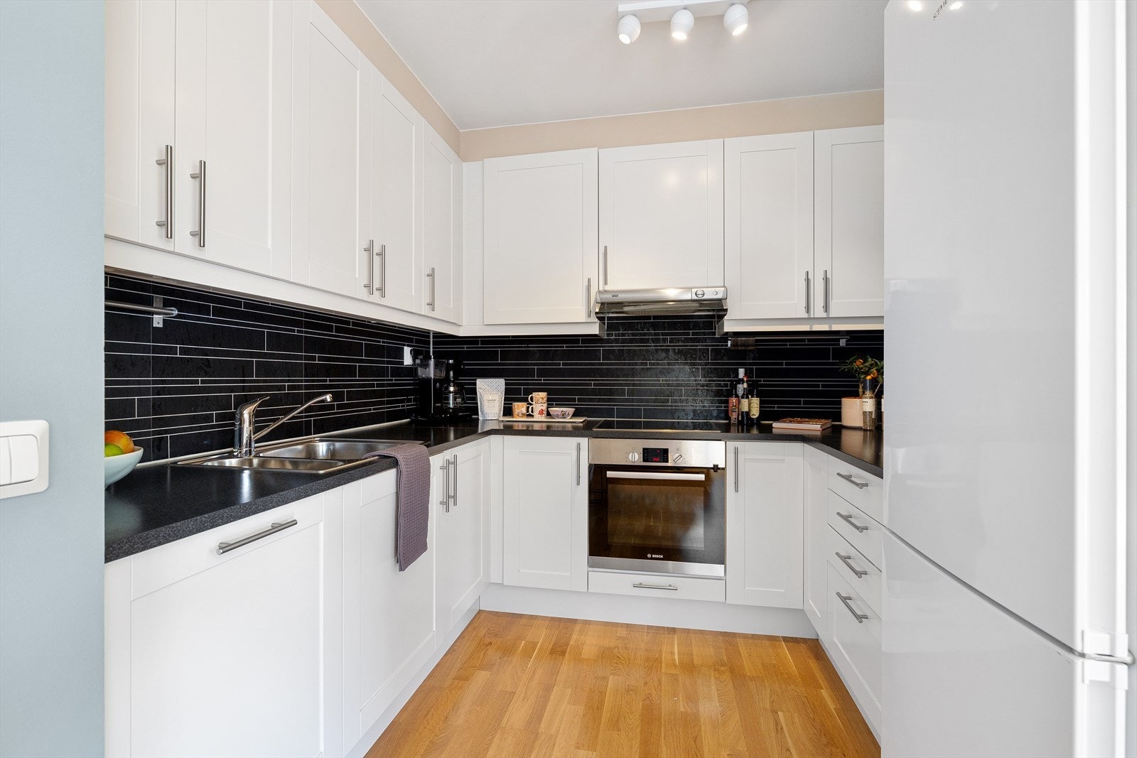 Lys og pen kjøkkeninnnredning fra Marbodal med profilerte fronter og en slitesterk benkeplate i laminat. Galleribilde