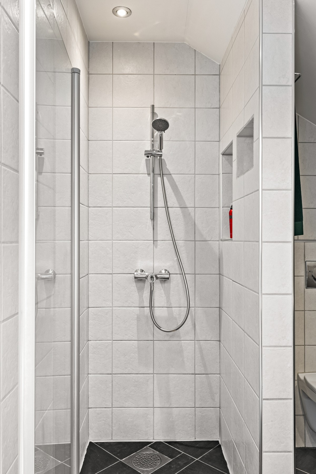 Dusjhjørne med dusjdør og dusjgarnityr montert på vegg. Galleribilde