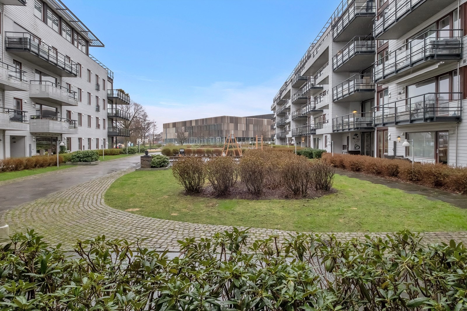 Leiligheten vender ut mot fellesareal - Tomten er pent opparbeidet og beplantet Galleribilde