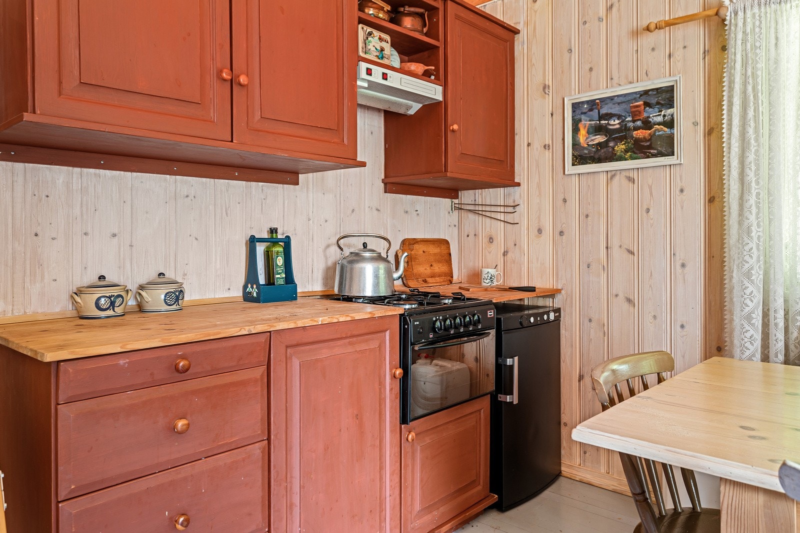 Plassbygget kjøkken med rødmalte fronter. Galleribilde