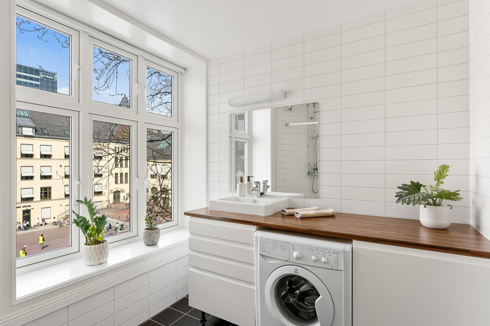 Baderommet er utstyrt med baderomsinnredning bestående benkeplate, benkeskap, speil og belysning over servant, dusj på gulv med forheng, servant, opplegg for vaskemaskin og veggfestet klosett. Galleribilde