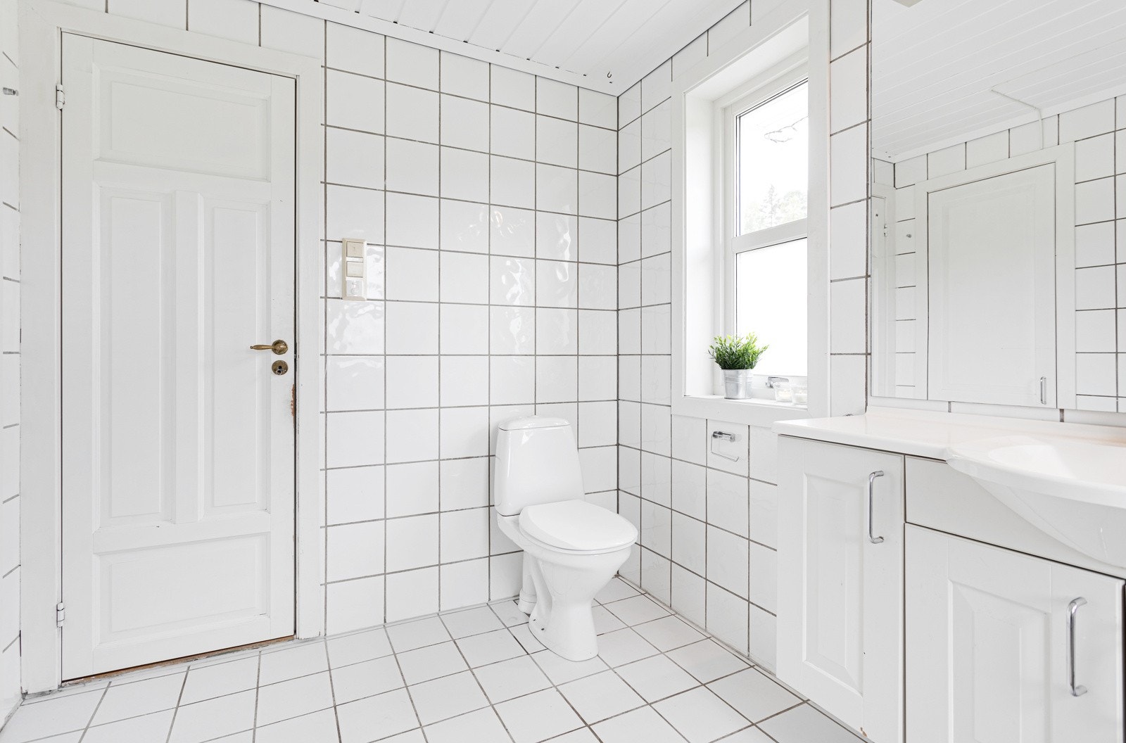 Badet i første etasje er fra 2001 og har lyse fliser på gulv og vegger Galleribilde
