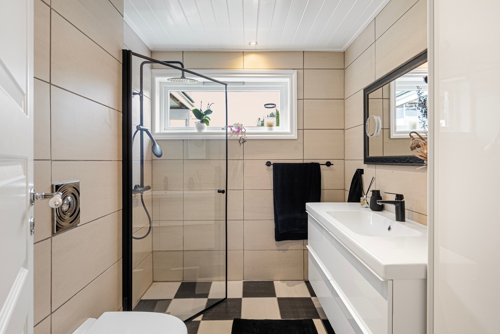 Badet ble i 2019 oppgradert med nytt vegghengt toalett og ny, moderne baderomsinnredning. Badet har downlights, beige veggfliser og sjakkmønstrede gulvfliser med varme. Et dusjhjørne er utstyrt med regnfallsdusj og en innfellbar glassvegg. Galleribilde