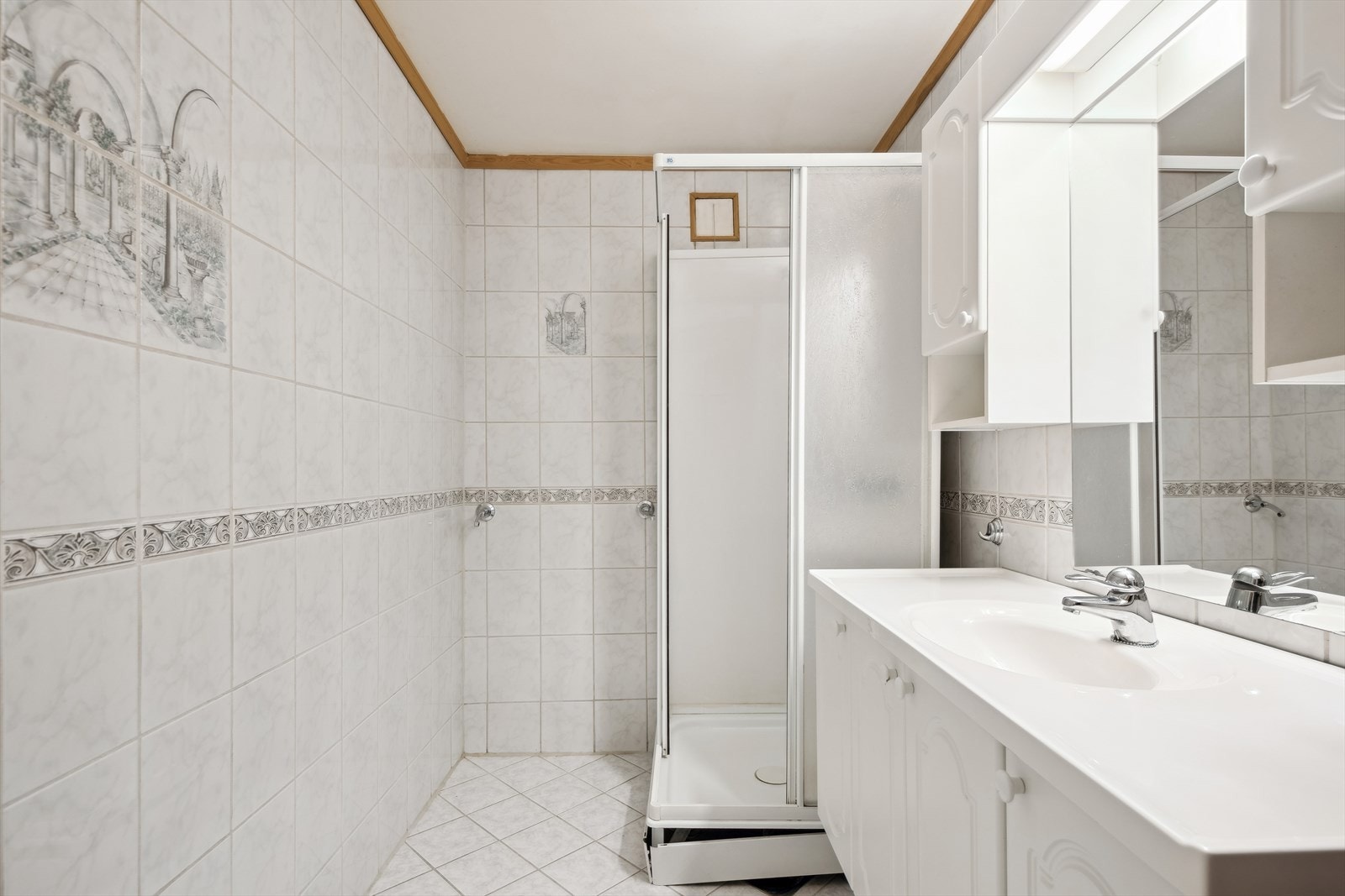 Dusjkabinett og opplegg for vaskemaskin på badet. Galleribilde