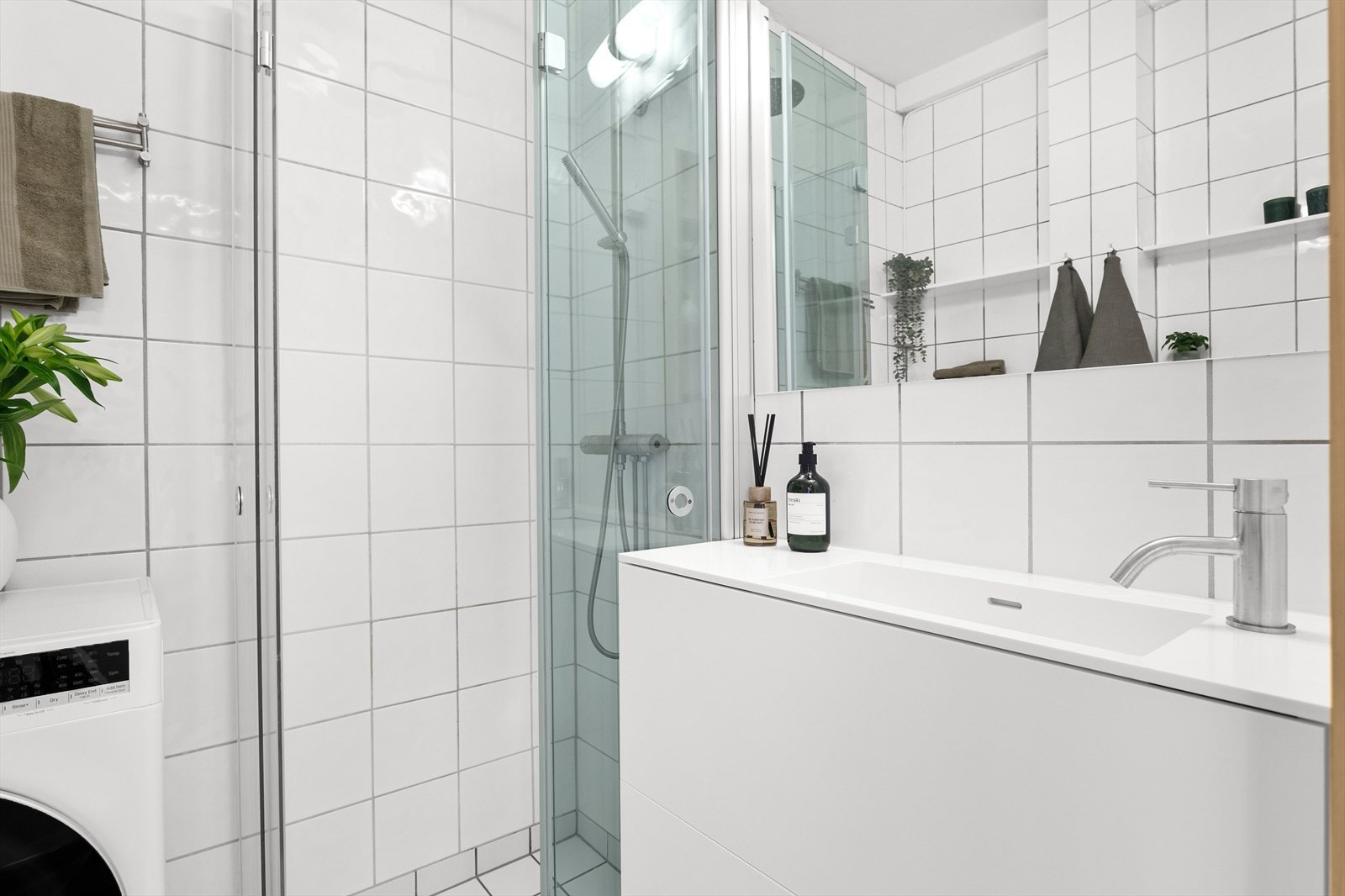 Badet har etablert dusjhjørne med innfellbare dører, toalett, servantskap/vask og opplegg for vaskemaskin/tørketrommel. Galleribilde