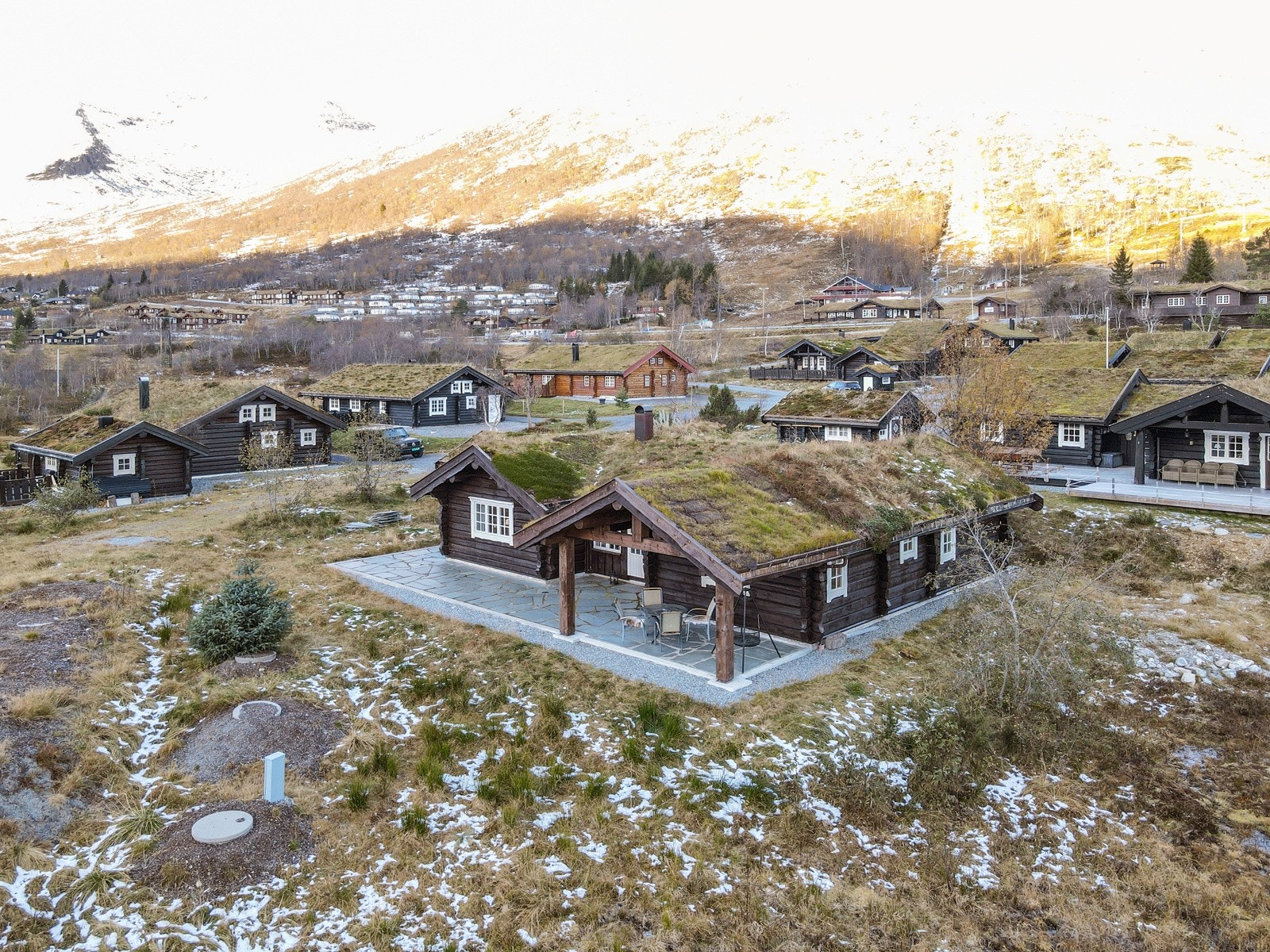 Hytten har pent tillagde uteområder med skiferbelagte gangstier og støpte plattinger Galleribilde