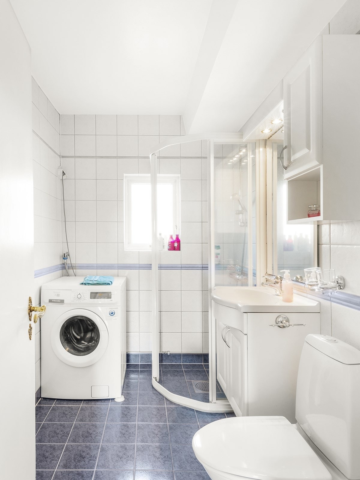 Dusjvegger i glass på skyvbar skinne. Veggmontert dusjstativ, med to-greps blandebatteri. Gulvmontert WC. Opplegg for vaskemaskin. Galleribilde